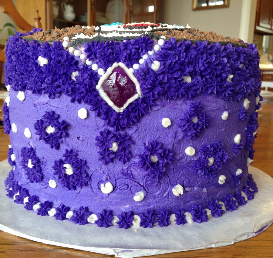 Purple princess dress cake with purple flowers and a jeweled amulet